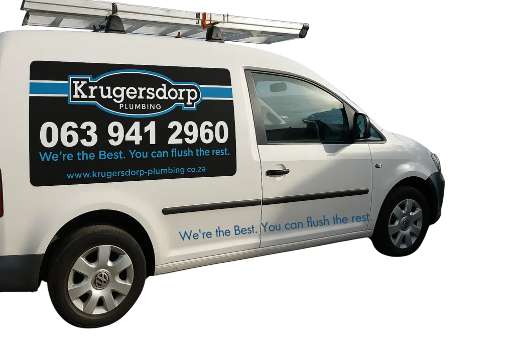 A white van with Krugersdorp Plumbing and their contact number, 063 941 2960, printed on the side. The slogan Were the Best. You can flush the rest. is visible. A ladder is mounted on the roof.